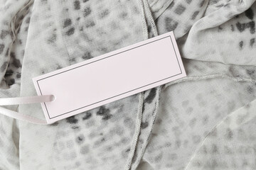 Close up of price tag of clothing item. Blank label tag mockup on clothes. Fashion industry and retail concept.	