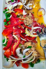 Fresh vegetable salad of red bell pepper and onion with tuna and sweet mustard sauce close-up