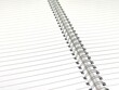 © Antonios - Top view of a spiral notebook, highlighting its carefully coiled metal binding that securely holds the pages together.