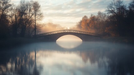 Wall Mural - A bridge over a misty river at dawn, with the early morning light just starting to break through the fog.