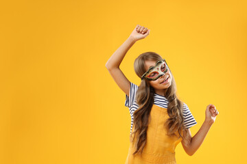 Wall Mural - Cute girl wearing carnival mask on orange background, space for text