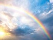 © amankris99 - A vibrant rainbow arcs beautifully across a cloudy sky, illuminated by soft sunlight, creating a serene and uplifting atmosphere.