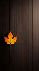 Wall Mural - A single orange maple leaf lies on a dark wood panel background, creating a minimalist autumn-themed design