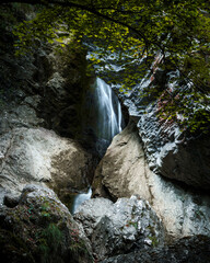 A waterfall in the forrest valley in early autumn