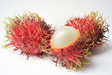 Wall Mural - Close up photograph of a rambutan fruit on white background. Healthy eating, natural sugars, tropical fruits. Rambutan is a source of vitamin C, fibre, several vitamins and minerals. 