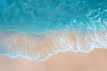 A top view of a tranquil beach with sparkling blue water 