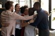 © Svetlana - Diverse team embraces new colleague with joyful congratulations in a modern office setting