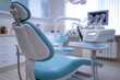 © Dm - Dental office. Patient chair and equipment for dental treatment. Blurred dental clinic background. Defocused interior of modern dental office.