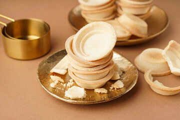 Plates with homemade tartlets on brown background