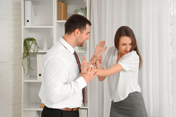 Poster - Business man grabbing his female colleague's hands in office. Harassment concept