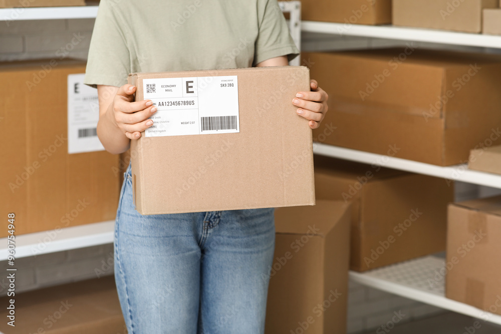 Woman with parcel at postal warehouse, closeup