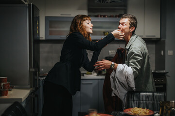 Poster - A playful couple is getting ready for a night out, sharing a meal in their cozy kitchen. The atmosphere is lighthearted and filled with excitement.