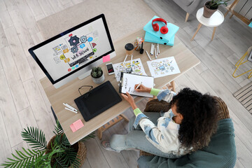 Poster - Female African-American web designer writing to-do list at table in office, top view