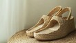 © Elnare - Close up of a pair of woven straw sandals on a wicker mat.