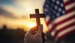 © iamfrk7 - Hand holding cross with American flag in background, religious patriotism, faith and freedom, sunset sky, symbol of belief, Christianity and nationalism, spiritual freedom, USA