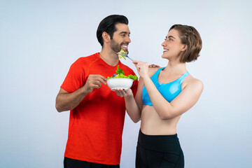 Wall Mural - Full body length gaiety shot athletic and sporty young couple with healthy vegan food in standing posture on isolated background. Healthy active and body care by vegetarian lifestyle.