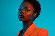 © Blockbits - Woman Bright Orange Blazer with Solid Neon Blue Chic Lifestyle Portrait with Neon Fashion Background