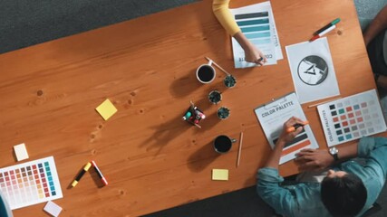Top view of manager writing idea on sticky notes and explain idea about web design. Professional marketing team or programmer brainstorming idea while looking at tablet with color palette. Symposium.