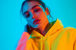 © Blockbits - Fashionable Womans Neon Yellow Hoodie with Solid Neon Blue Background Trendy Lifestyle Portrait with Modern Style