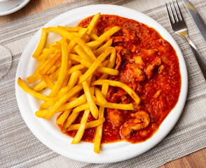 Sticker - On round white plate are pieces of stewed beef veal meat tenderloin fillet, garnished with French fries. Glass of dry red wine and slices of white bread are served for lunch