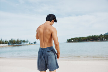 Wall Mural - Muscular Asian Man Running on the Beach: Active Lifestyle and Fitness at Sunset