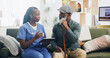 © peopleimages.com - Healthcare, tablet and senior man with nurse, explaining and caregiver with advice and nursing home. Living room, medical and black people in house, talking and remote monitoring of patient or health