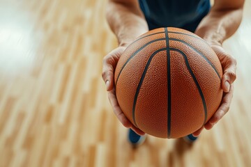 Detailed shot of a basketball player's hands gripping the ball on the court during a practice or match
