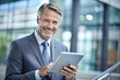 © Introvertia - Portrait of smiling businessman using tablet in office