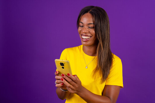 Happy african urban woman using mobile phone while smiling