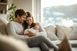 © lenblr - Young family is enjoying a quiet moment at home, cuddling with their newborn baby on the sofa