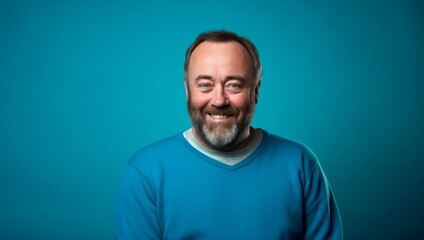 Wall Mural - A man with a beard and a blue shirt is smiling