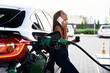 © standret - Having a conversation by phone. A young woman at a gas station with her car