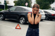 © standret - Feeling bad. Woman's car is broken, accident, standing outdoors