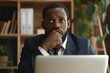 © Svetlana - Serious African American businessman pondering challenging news while seated at his office desk, hoping for a positive outcome during a crucial moment