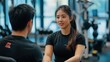 © CreativeSeven  - Young Woman and Man Engaging in Conversation at Modern Gym with Fitness Equipment in Background