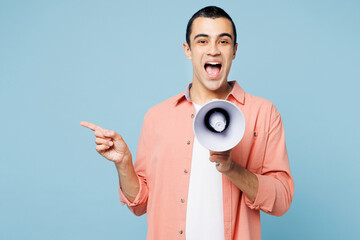 Poster - Young middle eastern man he wear pink shirt white t-shirt hold in hand megaphone scream announces discounts sale Hurry up point finger aside isolated on plain pastel blue background Lifestyle concept