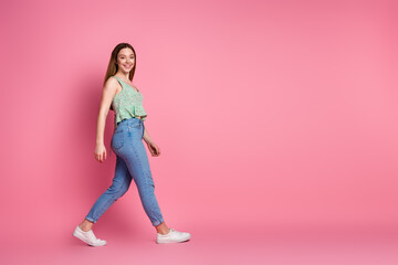 Wall Mural - Full size profile photo of nice young girl walk empty space wear top isolated on pink color background