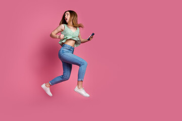 Wall Mural - Full size photo of nice young girl hold phone jump run away empty space wear top isolated on pink color background