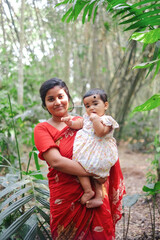 South asian young mother with her baby daughter in a outdoor park wearing traditional costumes