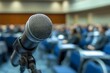 © irawan - Close-up of a microphone in a conference room with a blurred background of attendees.
