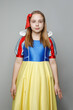 © millaf - Cheerful child girl with brown hair wearing snow white dress looking at camera on white background