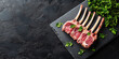 © Oleksandr - Fresh raw rack of lamb on a stone board with parsley. On a black background