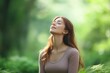 © kenkuza - Woman relaxing and breathing fresh air in green forest
