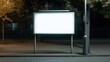 © angel_nt - A brightly lit blank billboard stands alone on a tranquil urban street at night, illuminated by the gentle glow of surrounding streetlights and featuring sparse trees in the background
