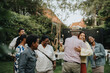 © Maskot - Happy family members greeting each other during social gathering at garden party