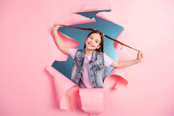 Sticker - Photo portrait of charming little girl have fun pull tails ripped paper poster wear trendy jeans outfit isolated on blue color background