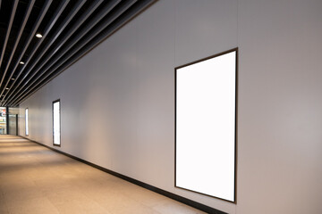 Wall Mural - Background texture of a mockup digital screen or blank white advertisement board on a wall in a long public corridor. Customizable copy space for vertical commercial ads in an underground hallway.