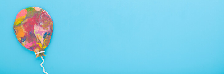 Wall Mural - Colorful balloon shape created from modeling clay on light blue table background. Pastel color. Closeup. Wide banner. Empty place for lovely text, quote or sayings. Top down view.
