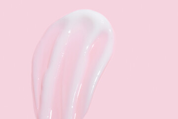 Poster - Smear of cosmetic cream or lotion on pink background. smear smudge stroke on color background. Creamy beauty product closeup