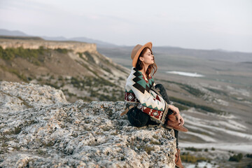 Wall Mural - serene woman in hat and poncho contemplating wyoming mountains from rocky perch